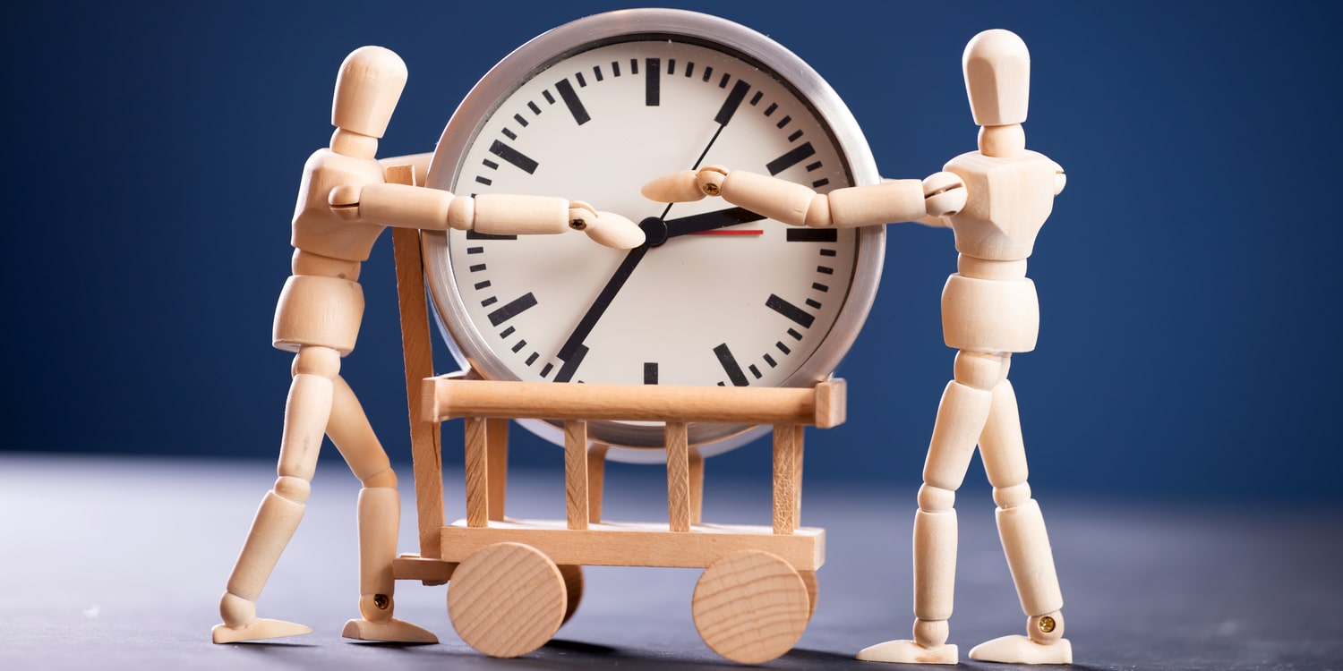 manichini di legno trasportano orologio e muovono lancette per gestire il tempo